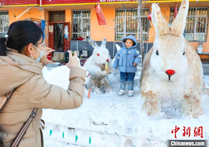 不少行人拍照上传朋友圈，这些雪雕兔子经社交平台传播一时成了当地“网红”。　杨俊钦 摄