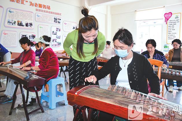 社区老年人在古筝班认真学习。