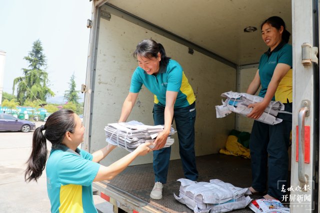 马国江（中间）与同事一起对当日报刊进行卸车.JPG